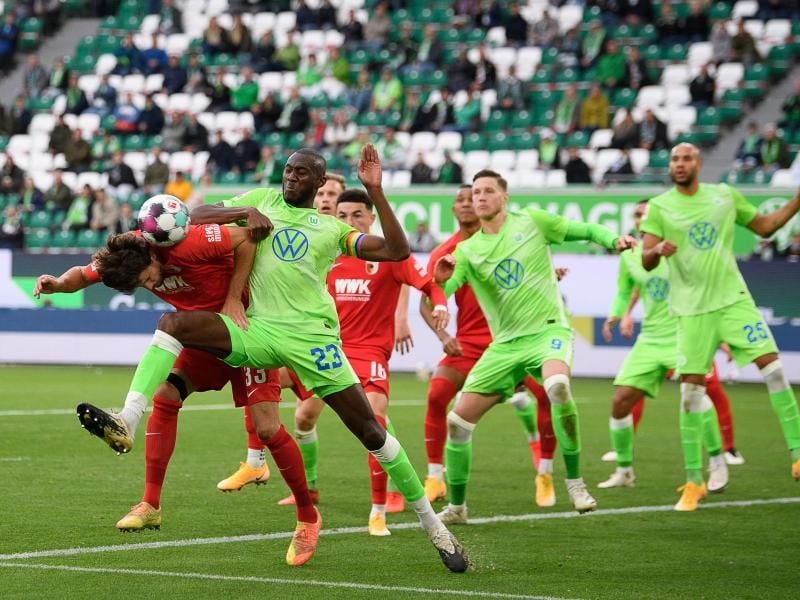 Josuha Guilavogui (3.v.l.) vom VfL Wolfsburg und Tobias Strobl, Spieler beim FC Augsburg, kämpfen um den Ball. Foto: Swen Pförtner/dpa