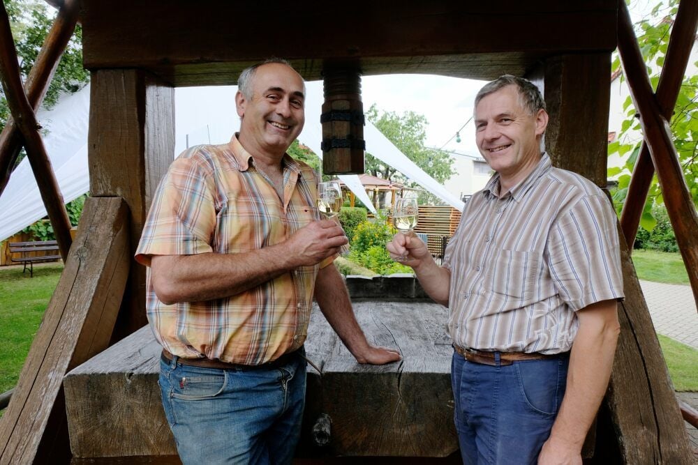 Frank und Ingo Hanke erwarten an diesem Samstag Gäste auf ihrem Familienweingut. Hier im Foto stehen sie vor der historischen Weinpresse.