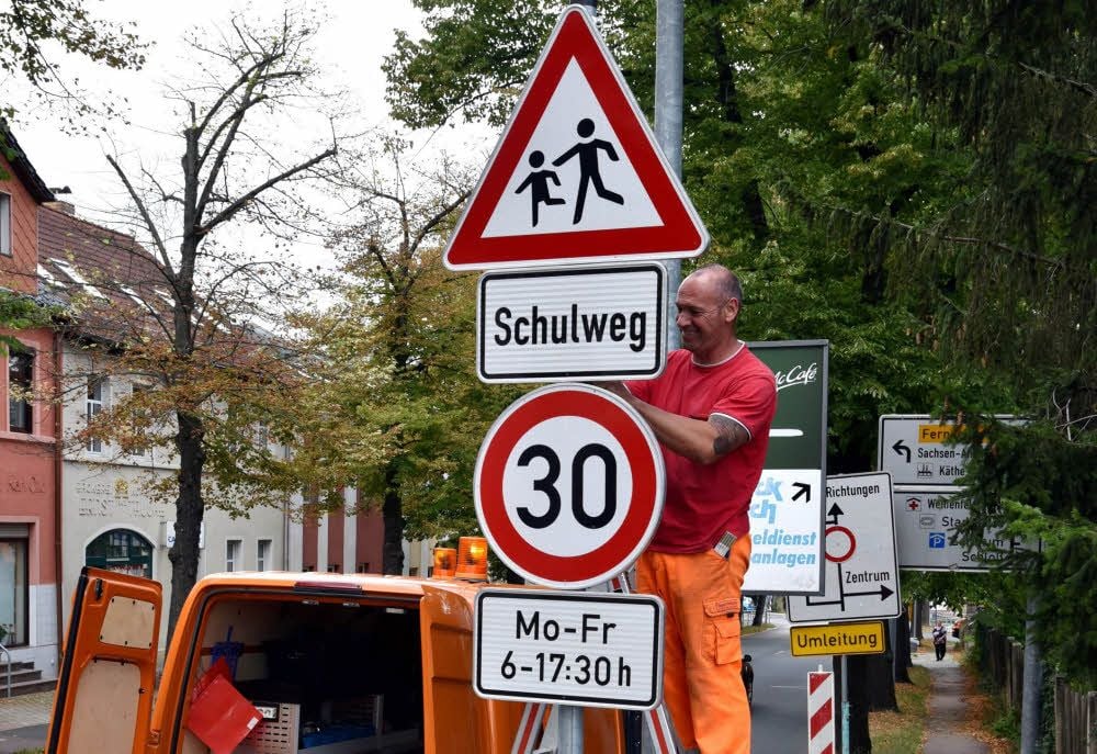 Mitarbeiter der Stadt Weißenfels bringen Schilder mit dem neuen Tempolimit in der Selauer Straße in Weißenfels an.