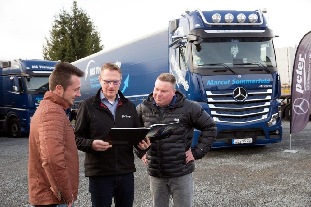 Fahrer David Eulitz (l.) und Spediteur Marcel Sommerfeld (r.) lassen sich von Vertreter Steven Bölke die Neuheiten des Fahrzeugs erklären.