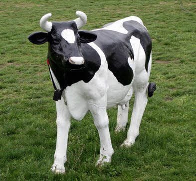 Auf der Wiese daneben steht das Maskottchen, eine Milchkuh aus Plaste.