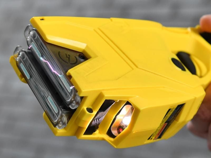 Eine Hand hält ein „Distanz-Elektroimpulsgerät” (DEIG) Taser X2. Foto: Arne Dedert