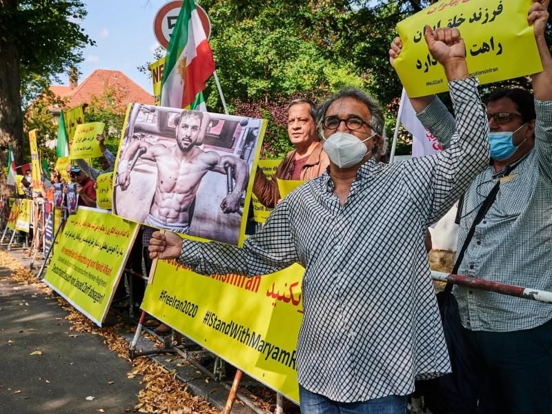 Vor der iransichen Botschaft zeigen Demonstranten Bilder des hingerichteten Ringers Navid Afkari. Foto: Annette Riedl/dpa