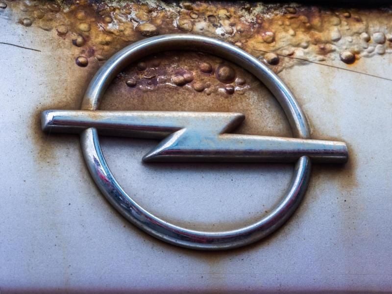 Opel-Logo mit Rost. Foto: Jens Büttner/Archiv