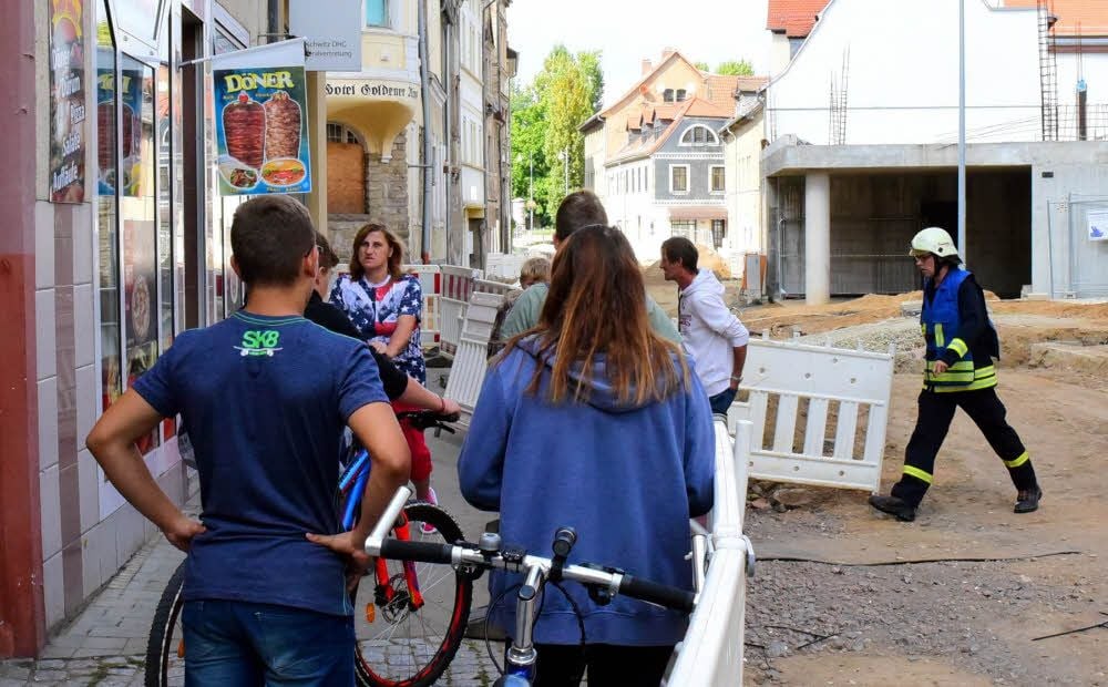 Das Dönergeschäft an der Saalstraße ist knapp einer Katastrophe entgangen. Menschen schauen zu, wie die Feuerwehr anrückt.