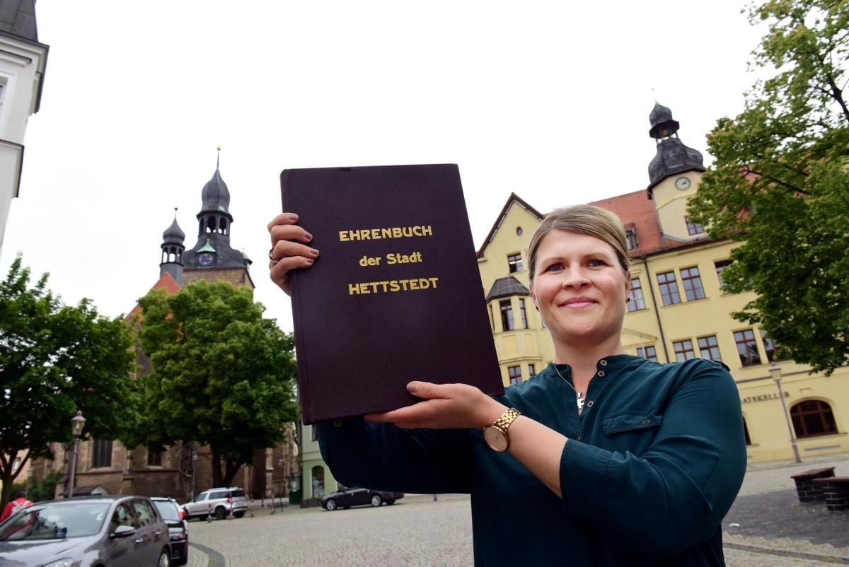Nadine Eisfeld aus der Hettstedter Stadtverwaltung zeigt das Ehrenbuch der Kupferstadt, in dem sich besondere Persönlichkeiten verewigen.