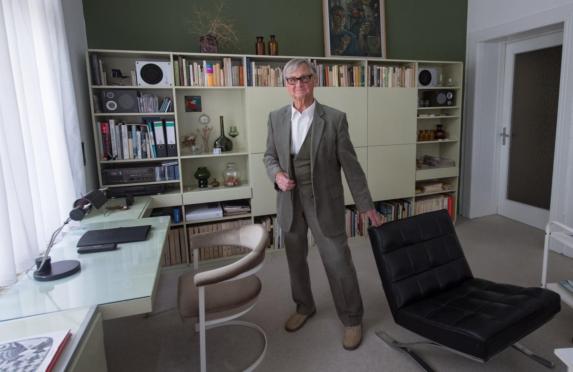 Der bekannte Möbelgestalter Rudolf Horn steht in seiner Wohnung in Leipzig in seinem Arbeitszimmer vor Möbelentwürfen der 1960er/70er Jahre.
