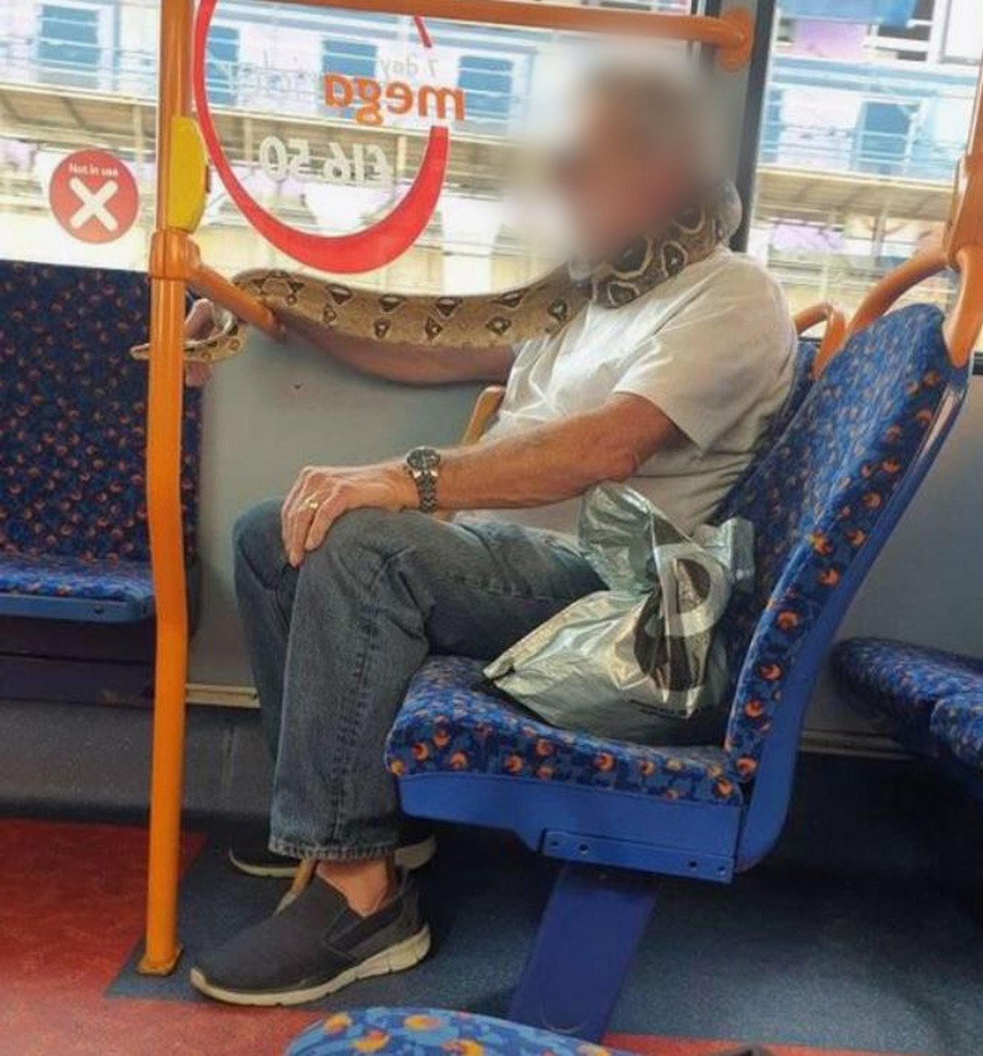 Der Mann trägt in einem Bus die Schlange offenbar als Ersatz für eine Corona-Maske. Er war mit dem Reptil um Nacken und Mund im Großraum der britischen Stadt Manchester unterwegs.