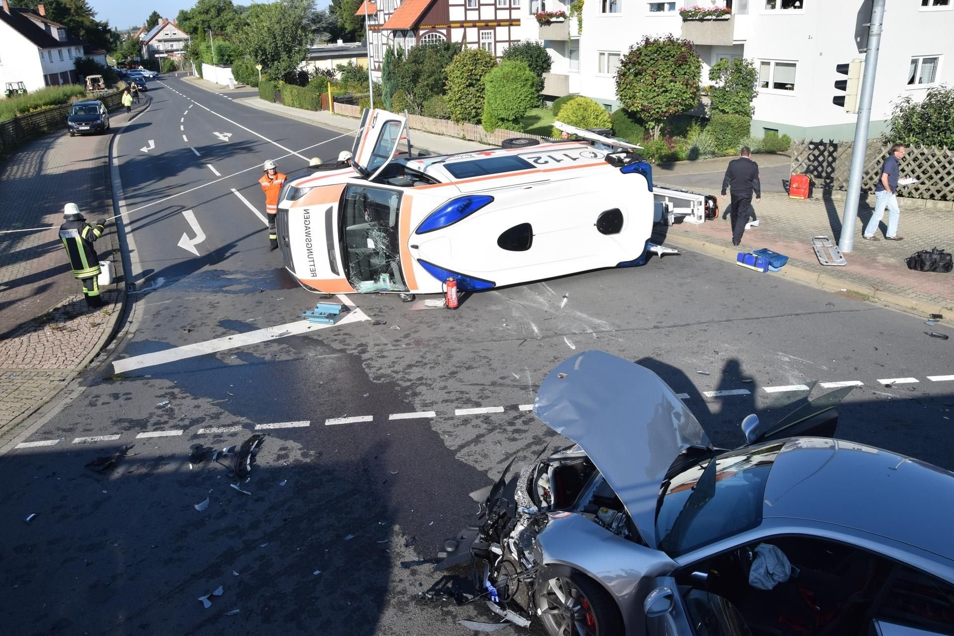Rettungskräfte stehen in Wolfenbüttel (Niedersachsen) um einen umgekippten Rettungswagen herum.