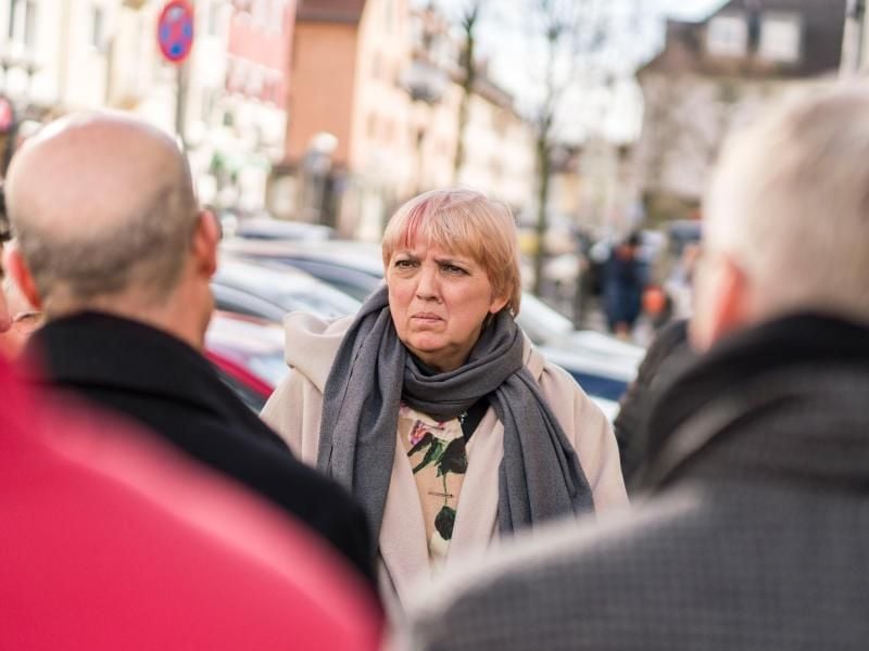 Claudia Roth (Bündnis 90/Die Grünen, M), Bundestagsvizepräsidentin, steht an einem der Anschlagsorte am Heumarkt in der Innenstadt, wo sie ein Blumengesteck niederlegte. Foto: Frank Rumpenhorst/dpa/Archivbild