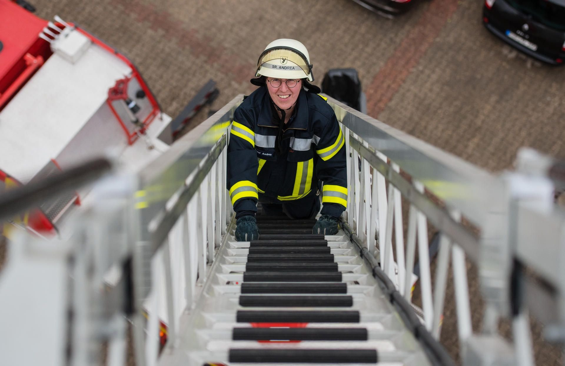 Schwester Andrea Stadermann klettert bei einer Übung in Rüdesheim (Hessen) eine Leiter nach oben.