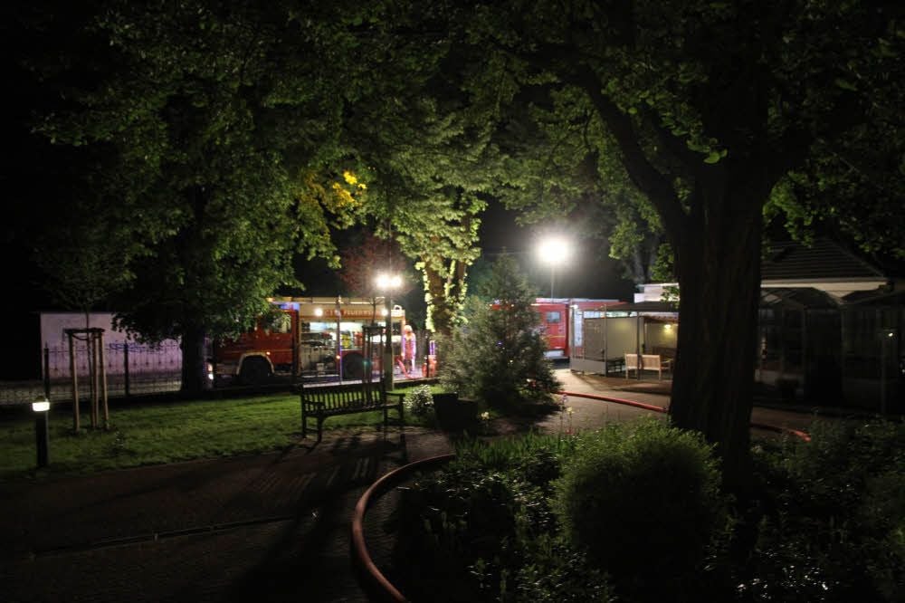 Zur abendlichen Stunden sind Feuerwehrautos vor Ort und leuchten den Einsatzort an der Klinik aus.