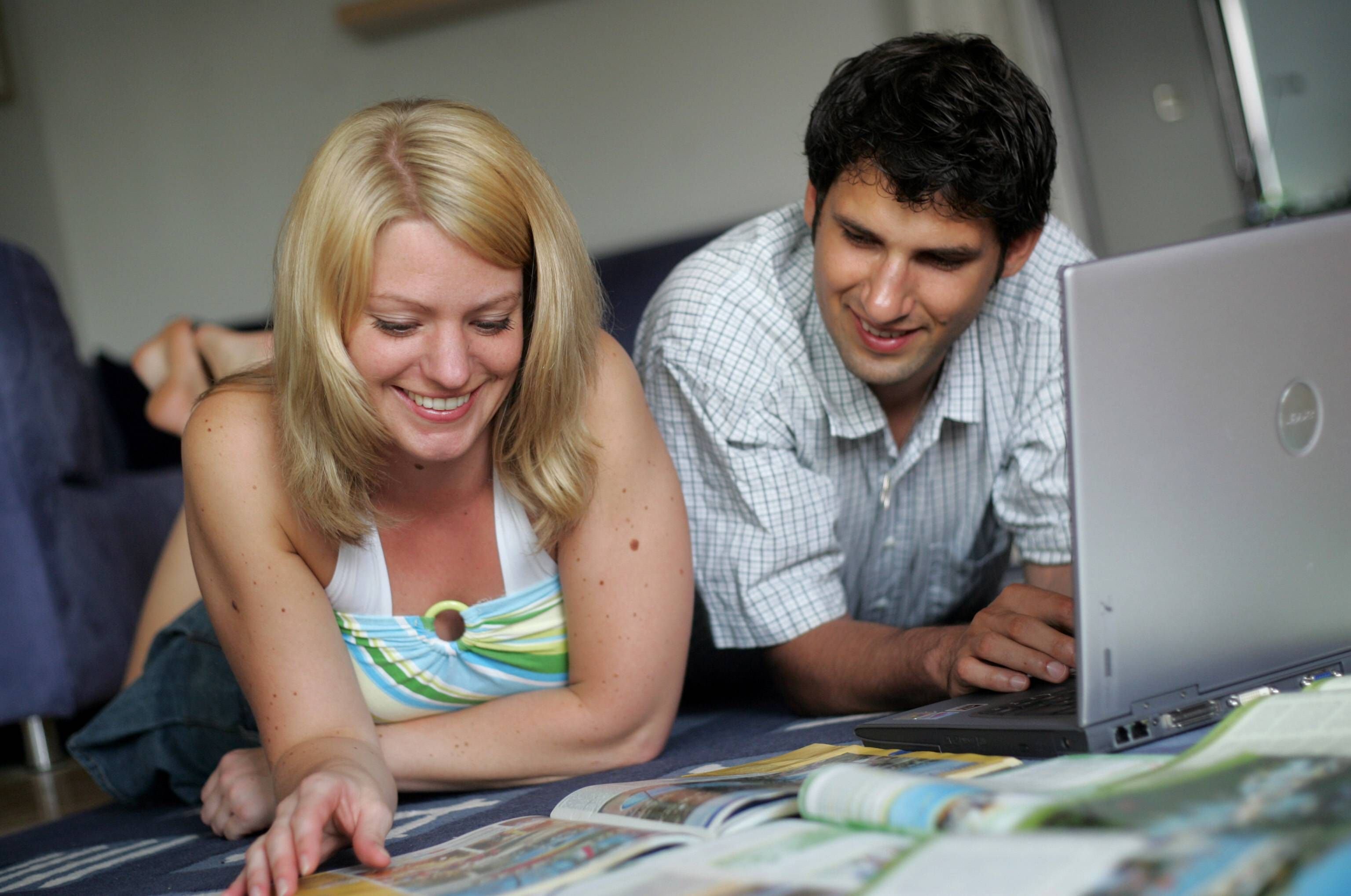 Ein Pärchen sucht gemeinsam nach den besten Angeboten für den gemeinsamen Urlaub.