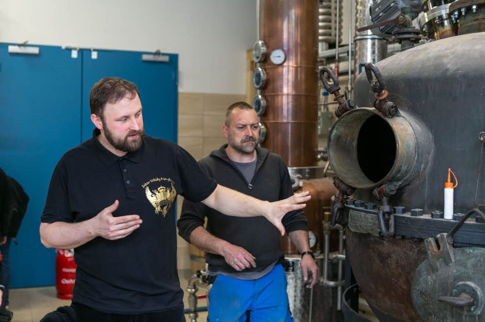 Der Chef der Whisky-Manufaktur Daniel Rost (li.) zeigt die alte Brennblase. Daneben verrichtet Handwerker Rico Kusenewski die letzten Arbeiten.