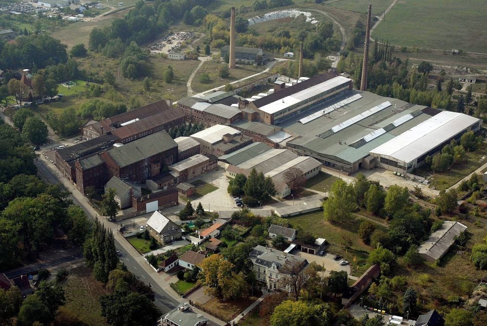 Das Luftbild gibt einen Gesamteindruck des ehemaligen Porzellanwerkes in Annaburg. Am unteren Bildrand: das Rathaus