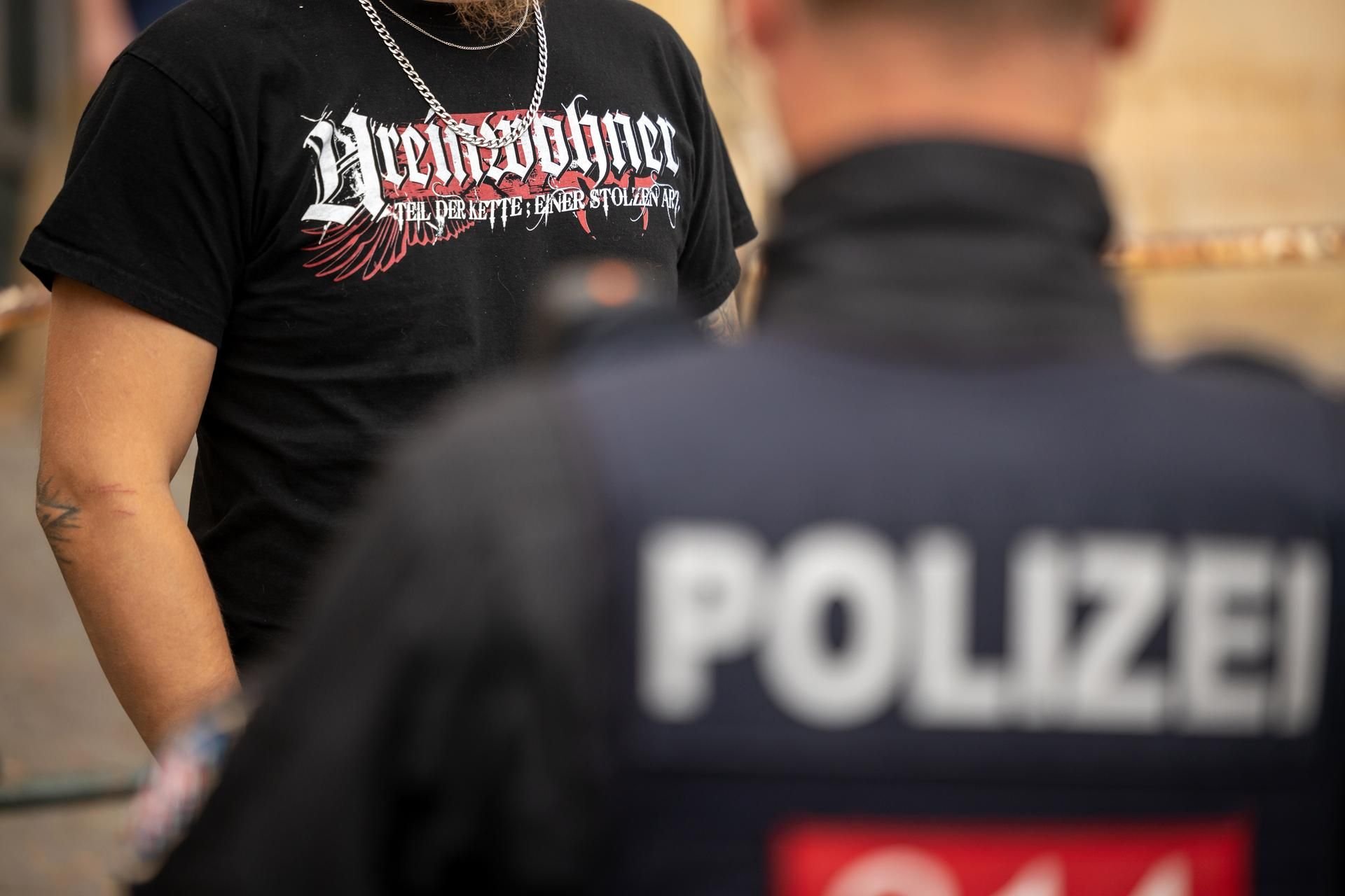Ein Teilnehmer einer von einem NPD-Funktionär angemeldeten Demonstration in Eisenach trägt ein T-Shirt mit der Aufschrift „Ureinwohner“, während er von einem Polizisten kontrolliert wird. Die NPD hatte zu der Demo nach einer angeblichen Vergewaltigung aufgerufen.