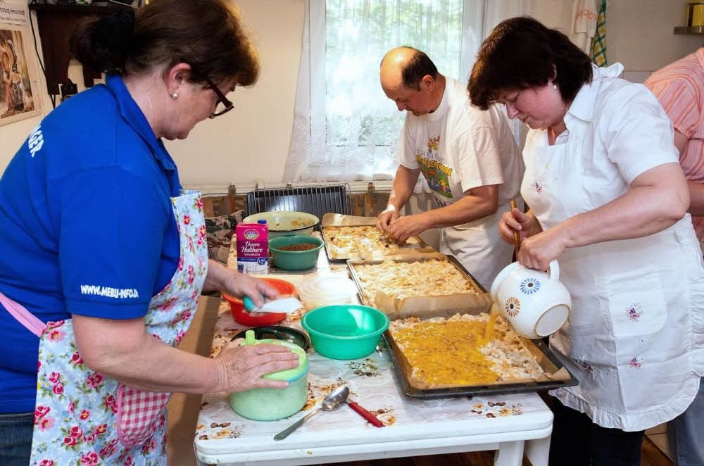 In der engen Küche von Marlene Faust wirbeln die vielen Helfer. Nicht ohne Grund: Für die feiernden Männer müssen 36 Speckkuchen gebacken werden.