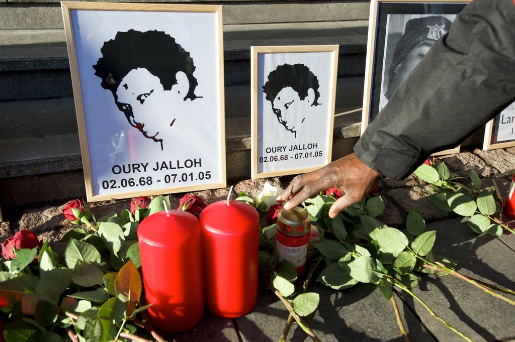 Rosen liegen vor dem Bild von Oury Jalloh, der 2005 in einer Dessauer Polizeizelle starb.
