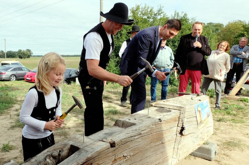 Zielstrebige und anstrengende Arbeit. Lenja-Marie Leder (links), Zimmermann Stefan Leder und der Bundestagsabgeordnete Sepp Müller (CDU) schlagen beim Richtfest die Nägel in den Balken. Im Anschluss erhält das Trio von den etwa 200 Besuchern viel Applaus.
