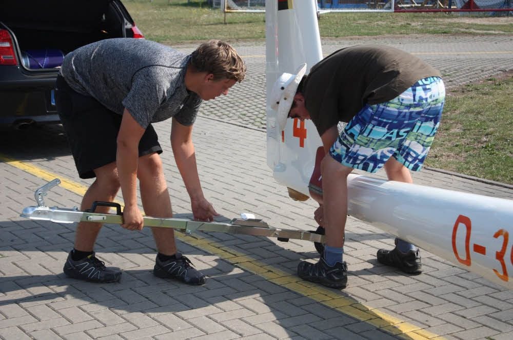 Zwei Teilnehmer bereiten den Segelflieger auf den Transport vor.