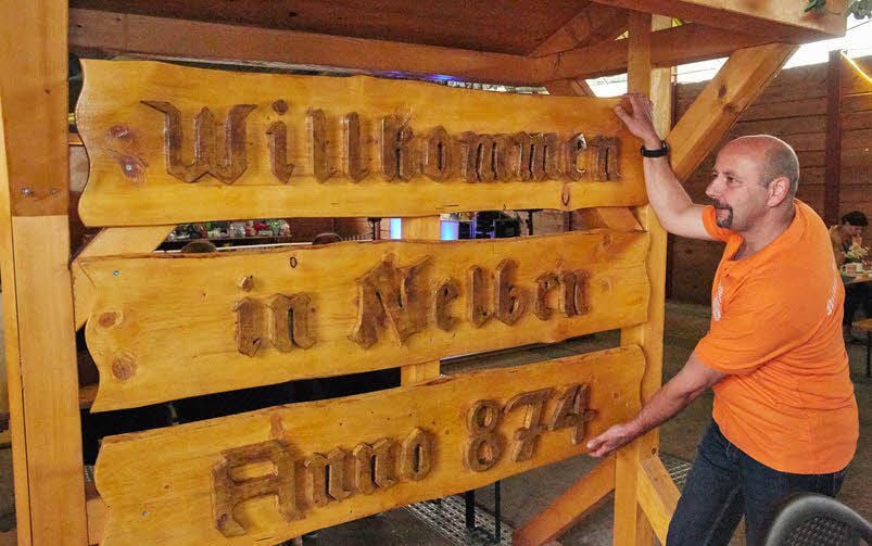Jörg Röthling zeigt eines von zwei neu angefertigten Willkommensschildern.