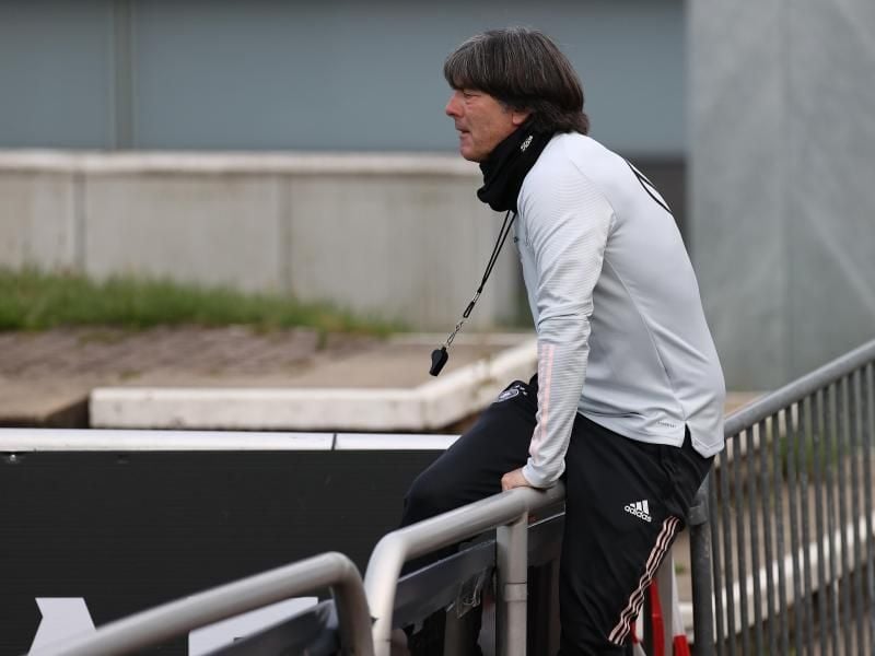 Joachim Löw klettert beim DFB-Training über eine Absperrung. Foto: Christian Charisius/dpa