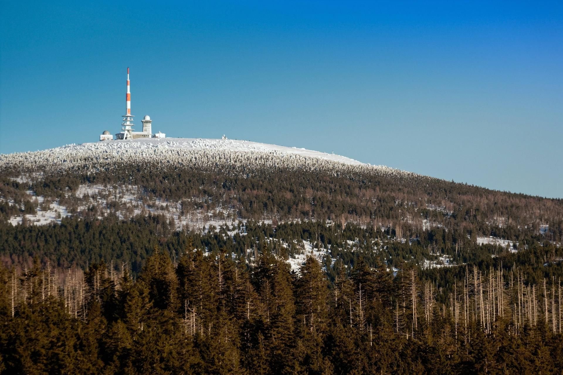 Blick aus Richtung Torhaus auf die leicht mit Schnee bedeckte Brockenspitze im Harz