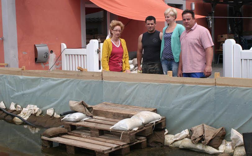 13. Juni 2013: Corina Günther, Sebastian Schräpler (Freund der Tochter), Carolin und Roberto Günther (v.l.) hinter ihrer selbst errichteten Spundwand. Erst am Vortag hatten sie die Pumpen abstellen können.