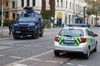 Einsatzfahrzeuge stehen auf einer Kreuzung Hauptstraße am Rand des Paulusviertels in Halle. Bei Schüssen sind zwei Menschen getötet worden.
