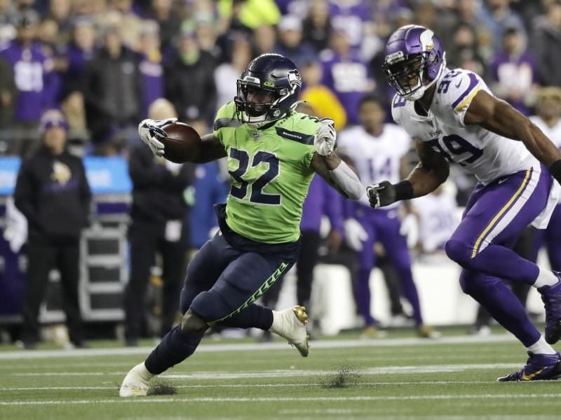 Chris Carson (l) von den Seattle Seahawks enteilt Danielle Hunter von den Minnesota Vikings. Foto: Ted S. Warren/AP/dpa
