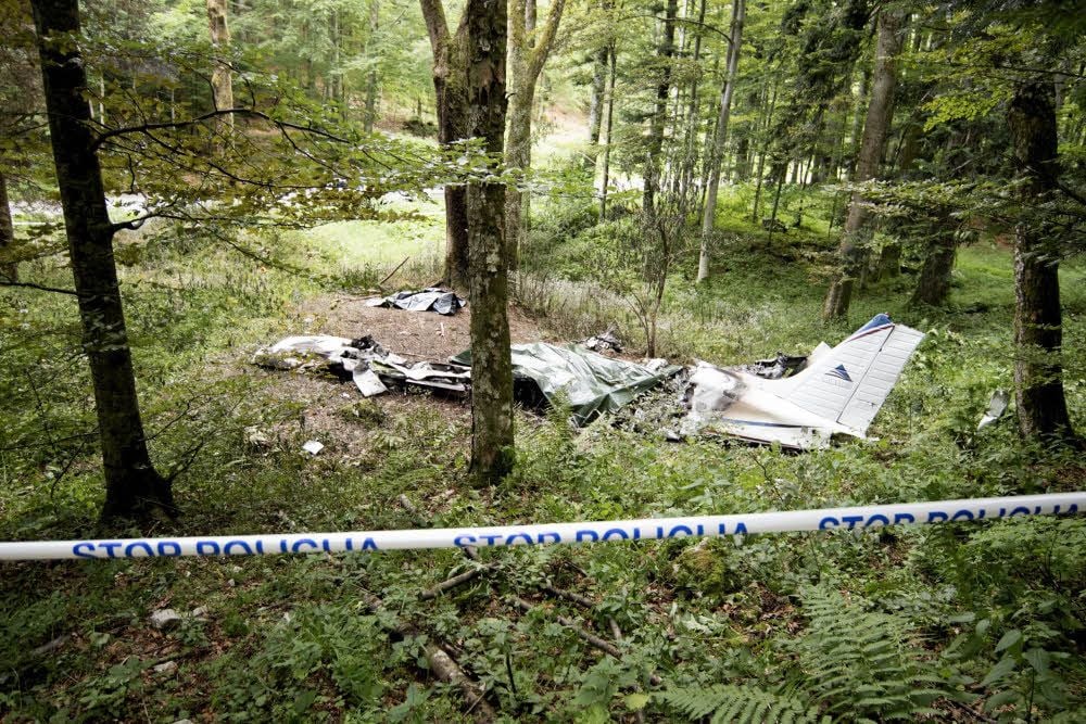 Ein Absperrband der Polizei sichert die Unfallstelle des abgestürzten Kleinflugzeugs in Predmeja (Slowenien) ab.