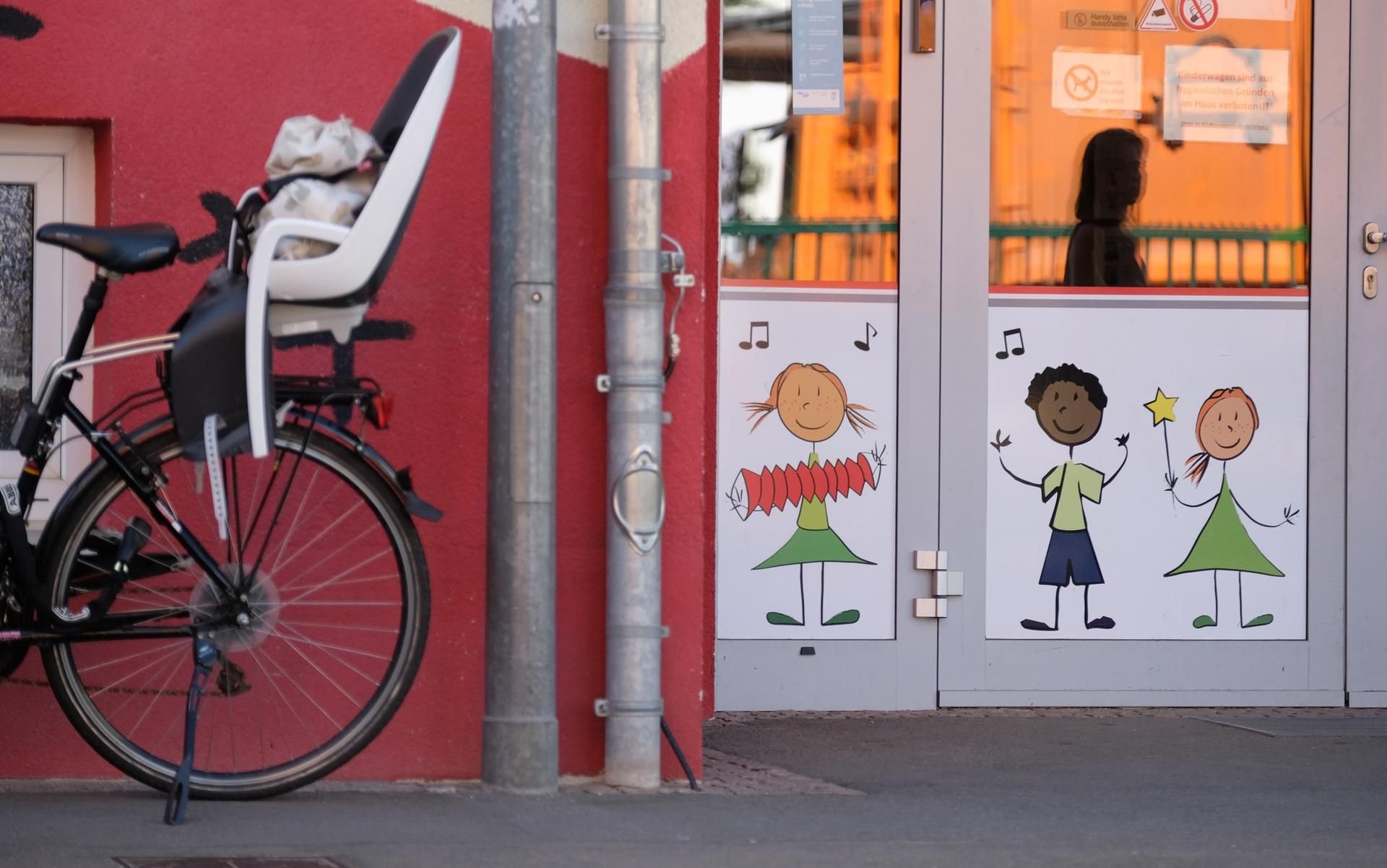 Sachsen, Leipzig: Ein Fahrrad mit Kindersitz steht am Eingang einer Kindertagesstätte.