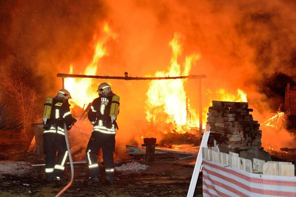 Feuerwehrleute löschen den Brand zweier Gartenlauben in Quarmbeck bei Quedlinburg.