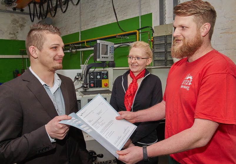 Mario Hesse (l.) bekommt von Ausbilder Michael Schwarze das Zeugnis. Er ist bester Azubi - zur Freude von Carolin Bayer von Pöttinger.