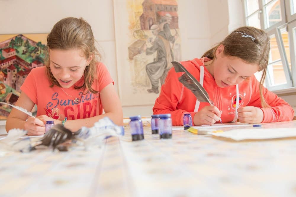 Schreiben mit Federkiel und Tinte: die Zwillinge Sophie und Marie (rechts) sind konzentriert dabei.