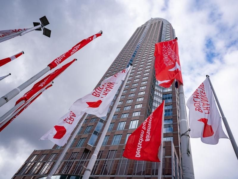 Fahnen mit der Aufschrift "Frankfurter Buchmesse" wehen vor dem Messeturm. Foto: Frank Rumpenhorst/dpa/Archiv