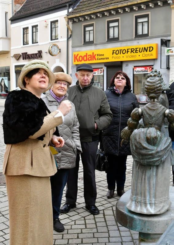 Jana Prokop (li.) erklärt am Palmenbrunnen die barocke Mode und lenkt den Blick auf das Geburtshaus des Modefotografen Horst P. Horst.