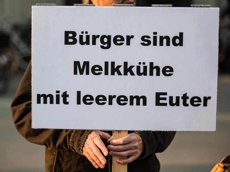 Ein Bürger demonstriert mit einem Plakat mit der Aufschrift "Bürger sind Melkkühe mit leerem Euter" gegen Abgabenlast. Foto: Andreas Arnold