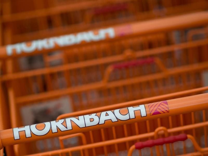Einkaufswagen der Baumarktkette Hornbach stehen vor einer Filiale. Foto: David Ebener/Archiv