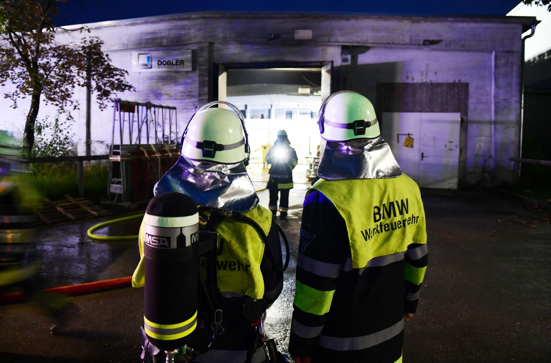 München: Einsatzkräfte der BMW-Werksfeuerwehr stehen vor einer Halle auf dem Werksgelände.