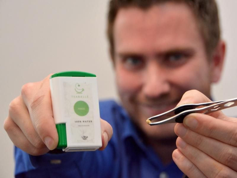 Erfinder Simon Schmidt präsentiert einen Spender mit Teaballs. Foto: Jörn Perske/dpa/Archivbild
