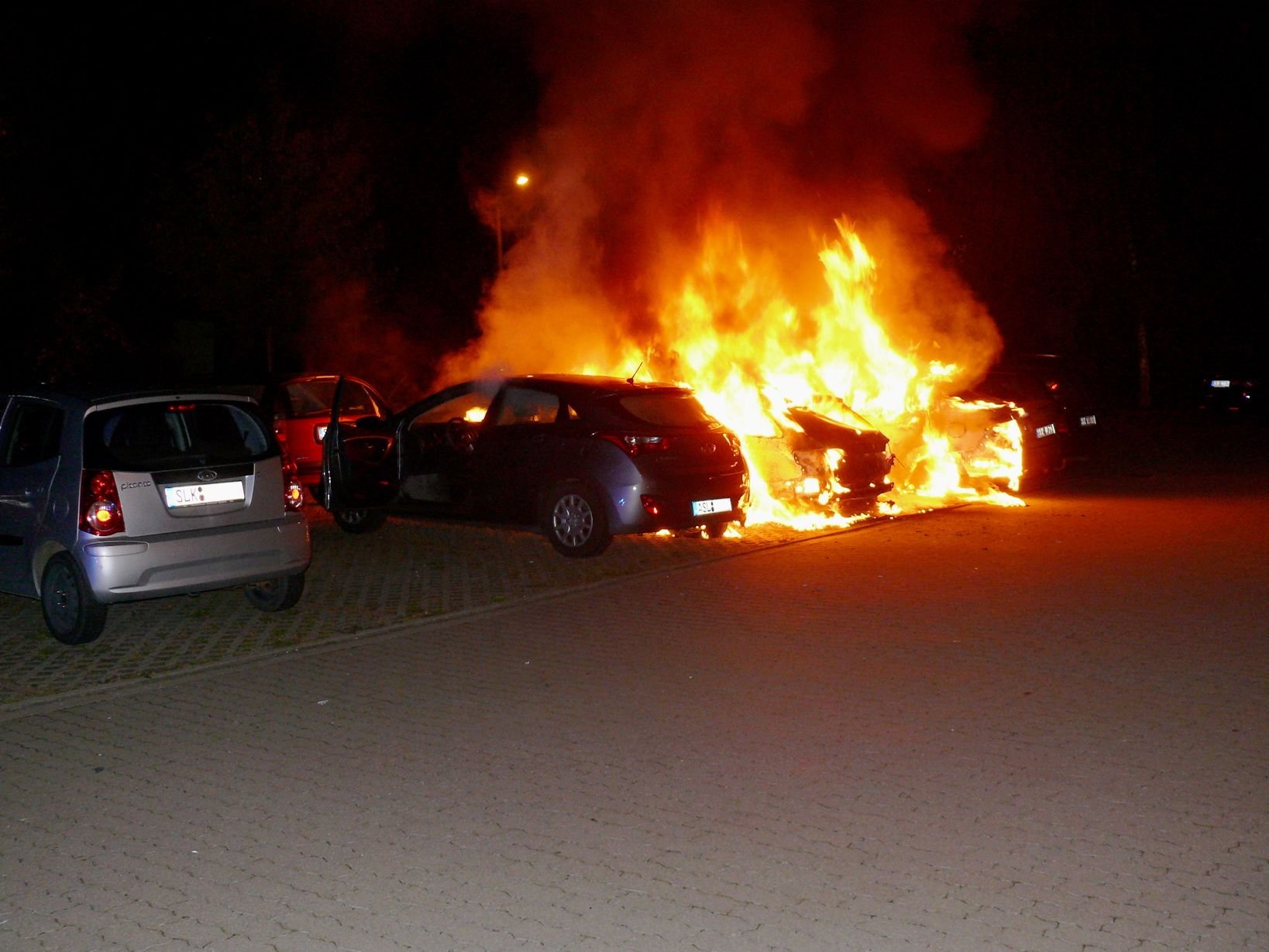 Die brennenden Autos auf dem Parkplatz in der Güstener Straße
