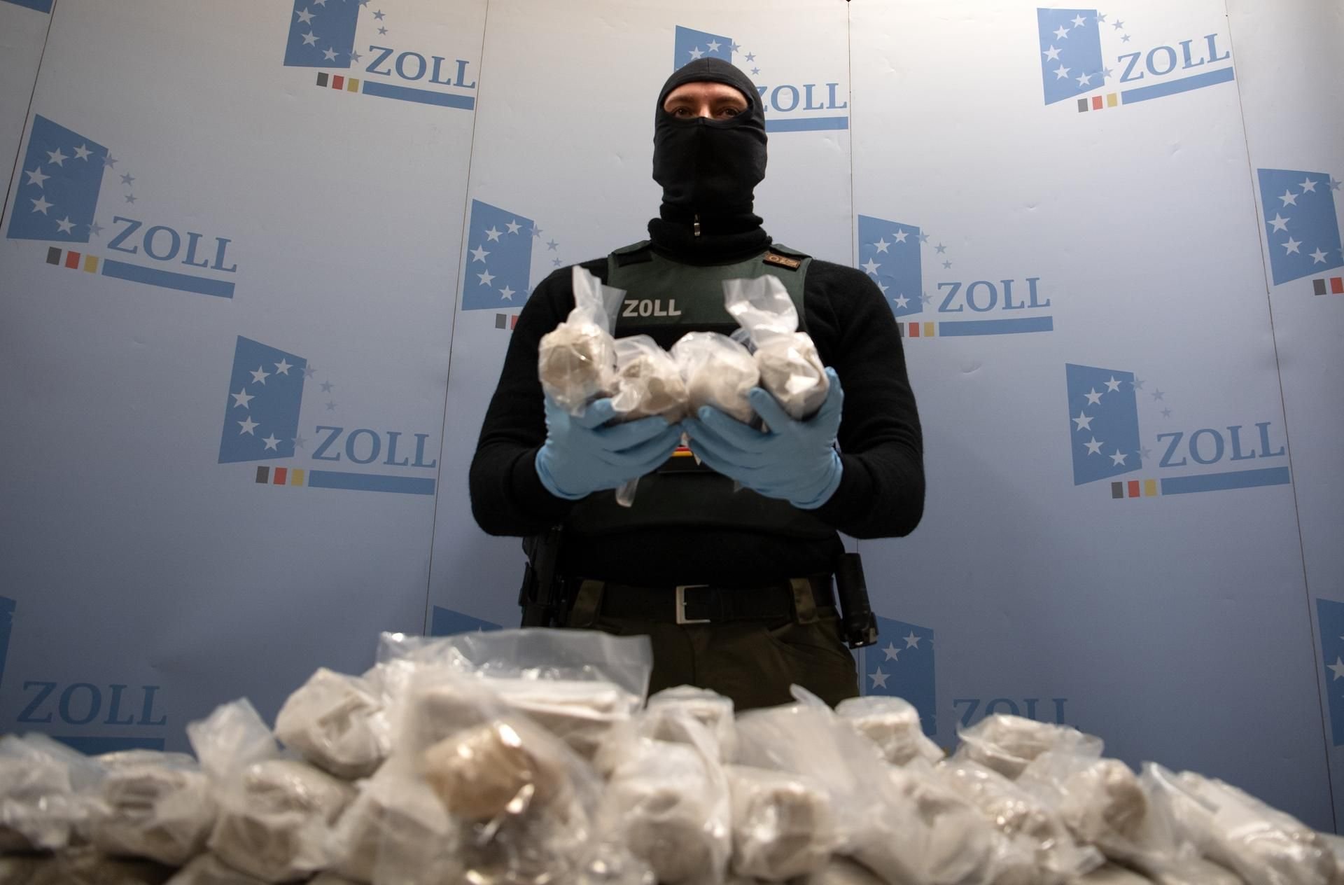 Ein Mitarbeiter des Zolls hält Päckchen mit Heroin. (Symbolbild)