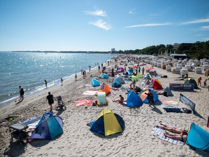 Zahlreiche Menschen am Ostseestrand. Foto: Daniel Reinhardt/dpa/Archivbild