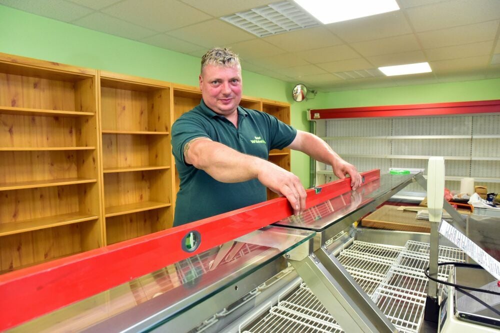 Andreas Wirth aus Mildensee bereitet die vier Meter lange Fleisch- und Wursttheke vor.