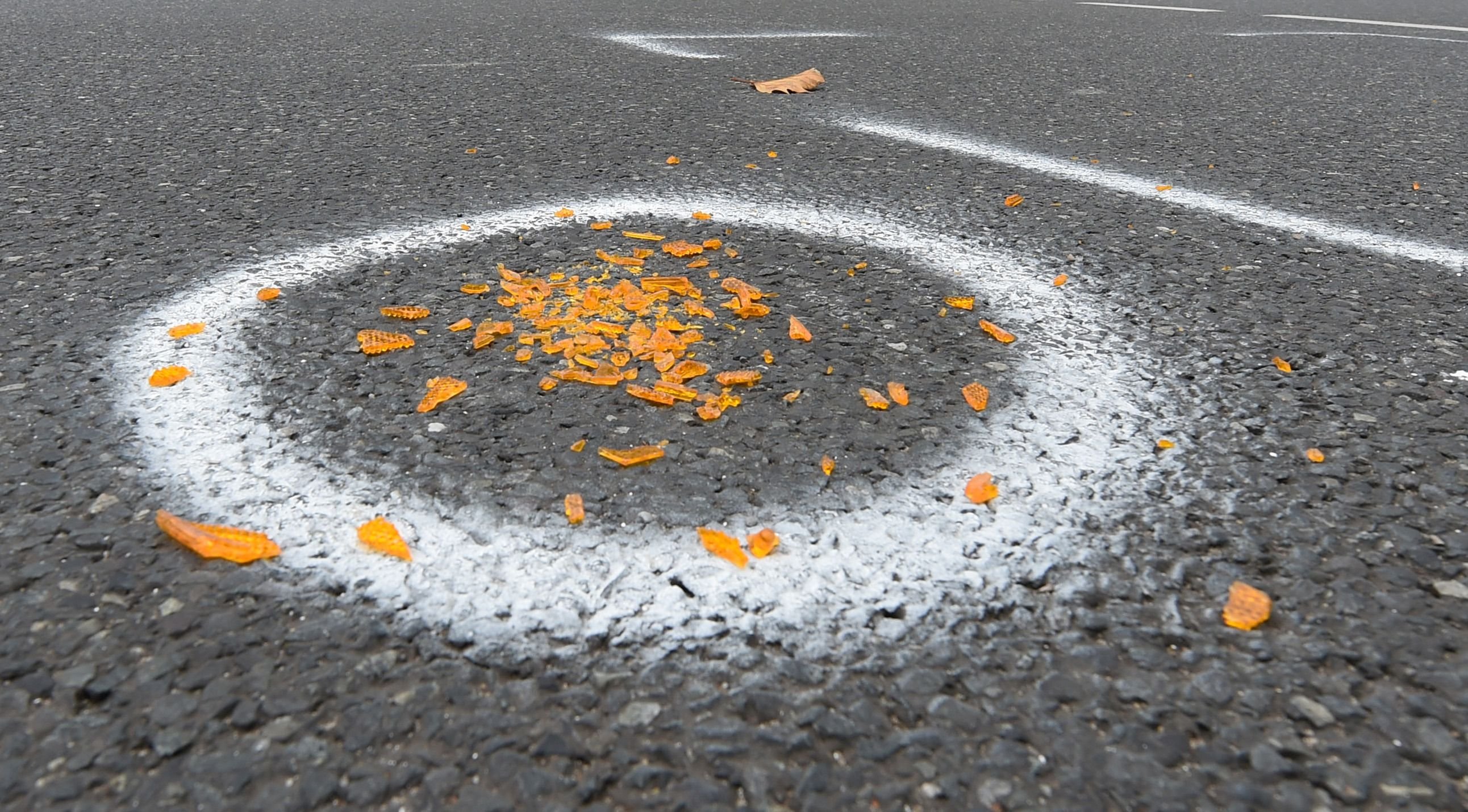 Scherben eines Blinker-Reflektors liegen, mit Farbspray markiert, an einer Unfallstelle.
