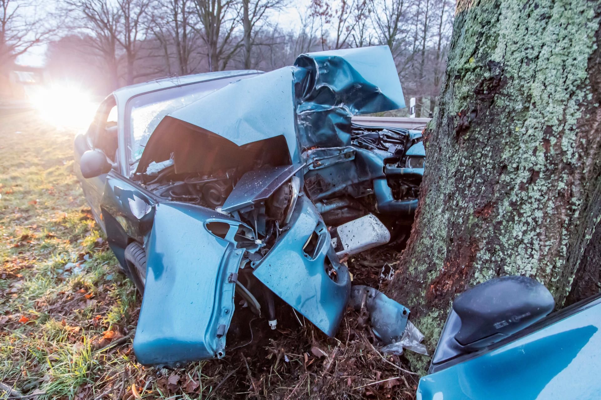 Das Wrack eines Autos liegt an einem Baum auf der Bundesstraße 169 bei Hainichen in Sachsen.