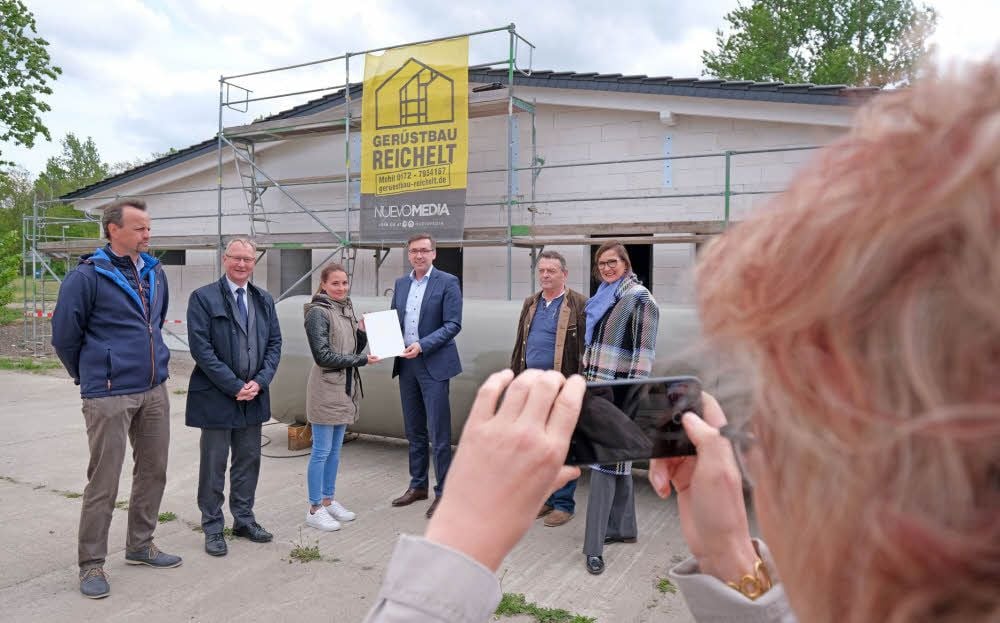 Staatssekretär Thomas Wünsch (4.v.l.) übergibt an Maria Grütze den Fördermittelbescheid des Landes Sachsen-Anhalt.