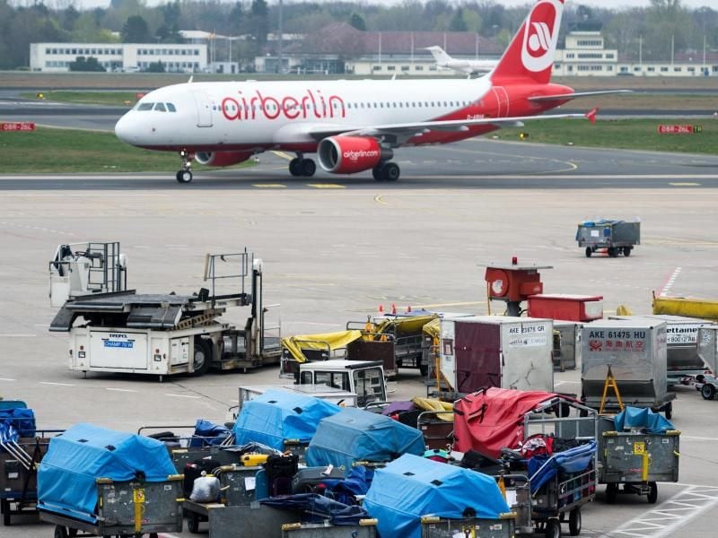 Zahlreiche mit Gepäckstücken beladene Gepäcktransportwagen auf dem Vorfeld am Flughafen Tegel in Berlin. Foto: Monika Skolimowska