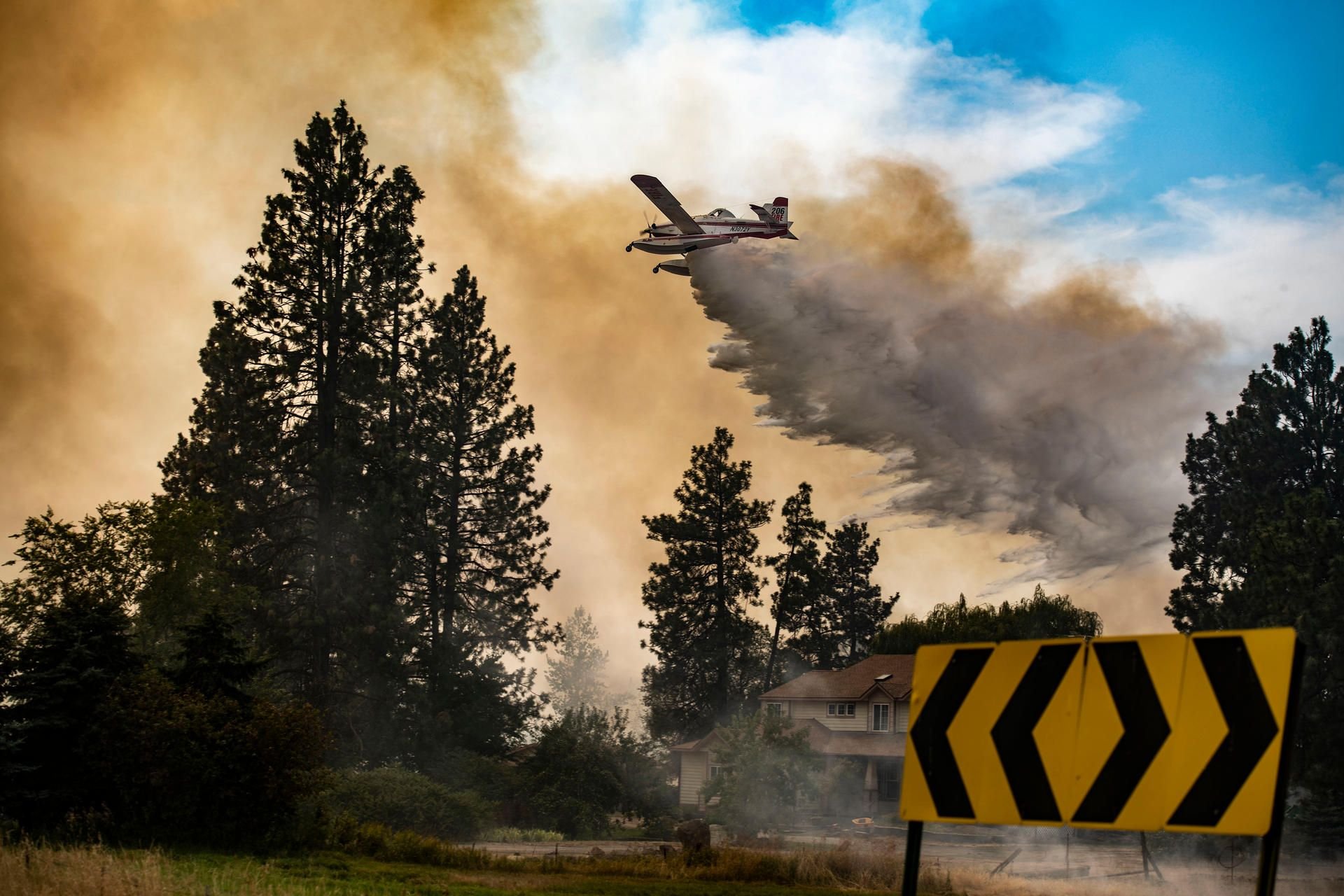 Ein Wasserflugzeug lässt Wasser auf das Feuer ab.